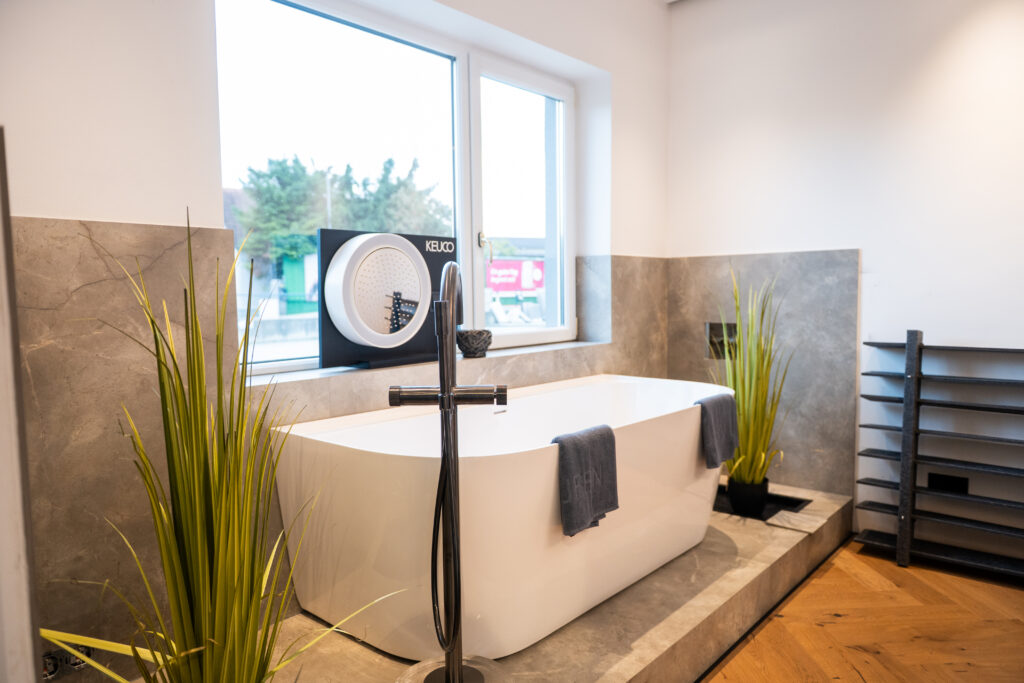 Freistehende Badewanne mit moderner Standarmatur im Schauraum von MABELA Fliesen und Handels GmbH – hochwertige Bad- und Fliesengestaltung.