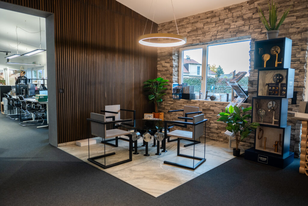 Moderner Schauraum von MABELA Fliesen und Handels GmbH mit Beratungsbereich, Natursteinwand und hochwertigen Sanitärlösungen.