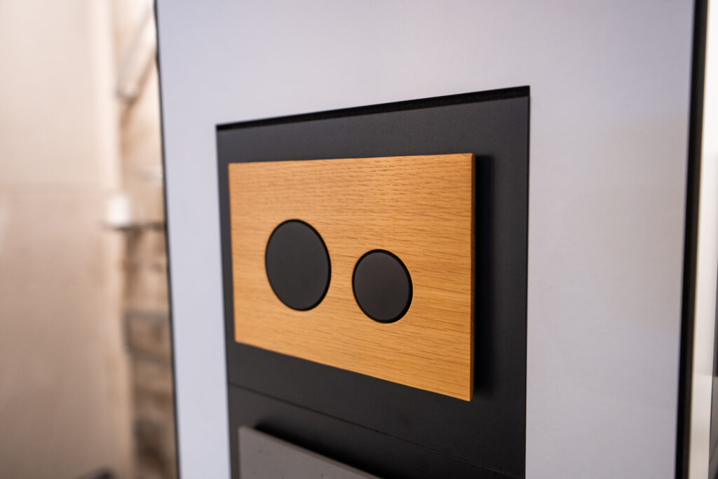 Moderne WC-Betätigungsplatte in Holzoptik bei MABELA Fliesen und Handels GmbH – hochwertige Sanitärtechnik für stilvolle Badgestaltung.