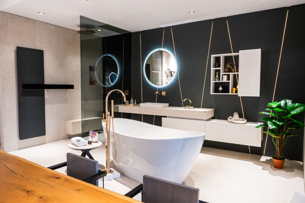 Luxuriöses Designerbad mit freistehender Badewanne und LED-Spiegel bei MABELA Fliesen und Handels GmbH – exklusive Fliesen- und Badgestaltung im Schauraum.